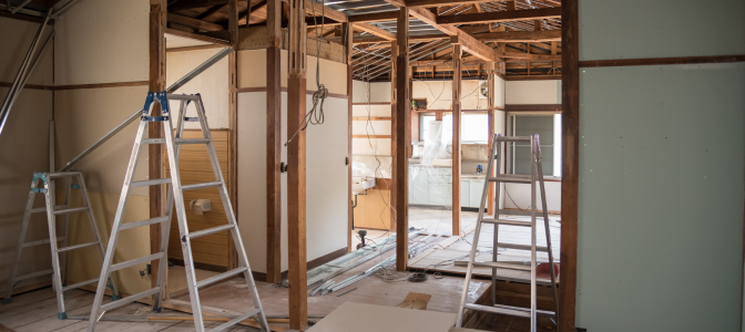 Ambiente em reforma com escadas e estruturas expostas, ilustrando a necessidade de guarda-móveis para proteger os itens durante a obra